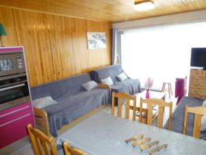 uma sala de estar com um sofá e uma mesa em Appartement Huez, 1 pièce, 4 personnes - FR-1-405-35 em Alpe-d'Huez