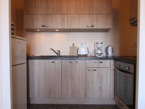 a kitchen with wooden cabinets and a sink at Appartement cosy 2P pour 6 pers. avec balcon, proche télésiège - Quartier Vieil Alpe, Huez - FR-1-405-49 in L'Alpe-d'Huez