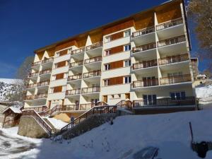 a large building with snow in front of it at Appartement cosy 2P pour 6 pers. avec balcon, proche télésiège - Quartier Vieil Alpe, Huez - FR-1-405-49 in L'Alpe-d'Huez