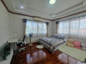 a bedroom with a bed and a desk and a television at Palmy House Homestay Udonthani in Udon Thani