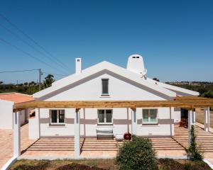 a white house with a large wooden deck at Courela da Lameira in Reguengos de Monsaraz