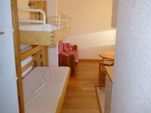 ラルプ・デュエズにあるAppartement Huez, 1 pièce, 4 personnes - FR-1-405-96の二段ベッドとテーブルが備わる小さな客室です。