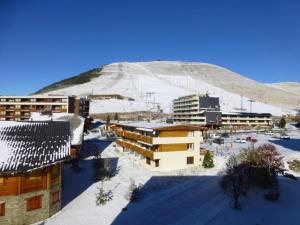 a group of buildings in front of a snow covered mountain at Appartement Huez, 1 pièce, 4 personnes - FR-1-405-96 in L'Alpe-d'Huez