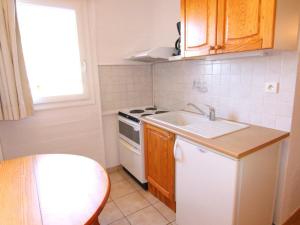 a small kitchen with a sink and a stove at Appartement Huez, 1 pièce, 4 personnes - FR-1-405-96 in L'Alpe-d'Huez
