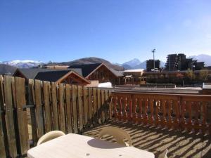 une clôture en bois avec une table et des chaises sur une terrasse dans l'établissement Studio chaleureux pour 4 pers. au pied des pistes - L'Alpe d'Huez - FR-1-405-19, à L'Alpe-d'Huez