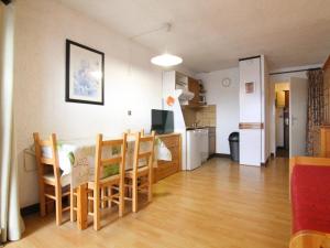 eine Küche und ein Esszimmer mit einem Tisch und Stühlen in der Unterkunft Appartement Huez, 1 pièce, 4 personnes - FR-1-405-19 in L'Alpe-d'Huez