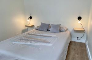 una camera da letto con un letto con due lampade sopra di Le Silly - Bel appartement - Paris & Parc des Princes a Boulogne-Billancourt