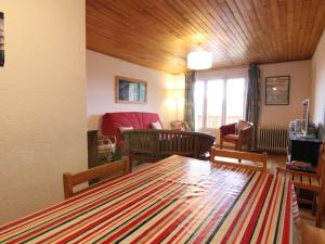 a living room with a table and chairs and a couch at Appartement Huez, 4 pièces, 8 personnes - FR-1-405-37 in L'Alpe-d'Huez