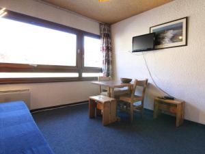 a room with a table and a tv on the wall at Appartement Huez, 1 pièce, 2 personnes - FR-1-405-91 in L'Alpe-d'Huez