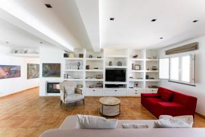 a living room with a red couch and a tv at Courela da Lameira in Reguengos de Monsaraz