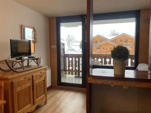 a living room with a television and a sliding glass door at Appartement Huez, 2 pièces, 4 personnes - FR-1-405-112 in L'Alpe-d'Huez