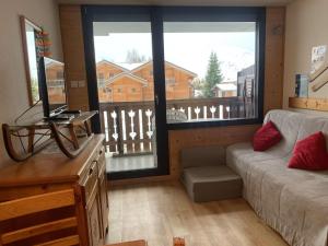 a living room with a couch and a large window at Appartement Huez, 2 pièces, 4 personnes - FR-1-405-112 in L'Alpe-d'Huez