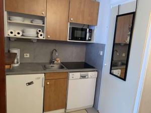 a small kitchen with a sink and a microwave at Appartement Huez, 2 pièces, 4 personnes - FR-1-405-112 in L'Alpe-d'Huez