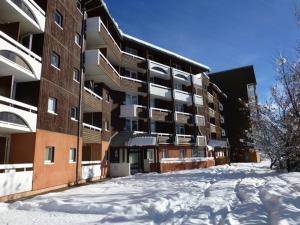 a snow covered parking lot in front of a building at Appartement Huez, 2 pièces, 4 personnes - FR-1-405-111 in L'Alpe-d'Huez