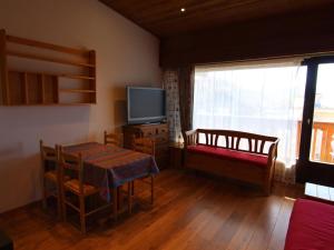 a living room with a dining table and a tv at Appartement Huez, 1 pièce, 4 personnes - FR-1-405-117 in L'Alpe-d'Huez