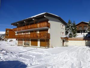 um edifício com neve em frente em Appartement Huez, 1 pièce, 4 personnes - FR-1-405-117 em Alpe-dʼHuez