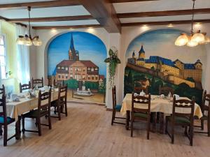 a dining room with a mural of a city at Hotel zum Hirsch in Lucka
