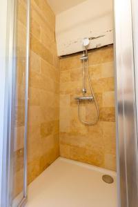 La salle de bains est pourvue d'une douche avec une porte en verre. dans l'établissement Le Petit Yogi, 5 minutes du ZooParc de Beauval, à Saint-Aignan