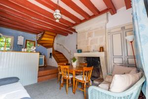 - un salon avec une table, des chaises et une cheminée dans l'établissement Le Petit Yogi, 5 minutes du ZooParc de Beauval, à Saint-Aignan