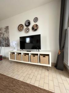 salon z telewizorem i białą szafką w obiekcie T2 VUE PANORAMIQUE SUR MER QUARTIER DES QUILLES w mieście Sète