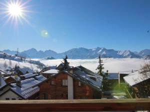 una vista de una montaña nevada con el sol en el cielo en Appartement Huez, 1 pièce, 4 personnes - FR-1-405-134, en L'Alpe-d'Huez