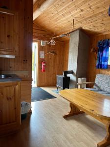 uma cozinha e sala de estar com uma mesa e um fogão em Atnasjø Kafe AS em Sollia