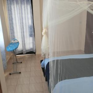um quarto com uma cama e uma cadeira azul e uma janela em Miguel's haven, Homely vibes! em Kakamega
