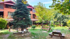 サパンジャにあるSapanca Gönül Sofram Hotel & Bungalow & Villasのピクニックテーブルと木のある家