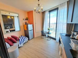 a living room with a couch and a large window at Downtown Chic Condo High Floor #ES54624 in Pattaya Central