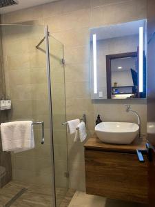 a bathroom with a sink and a glass shower at Kiran Lodging Guayaquil in Guayaquil
