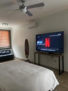 um quarto com uma televisão de ecrã plano e uma cama em Kiran Lodging Guayaquil em Guayaquil