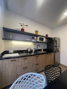 a kitchen with a refrigerator and a table and chairs at Kiran Lodging Guayaquil in Guayaquil