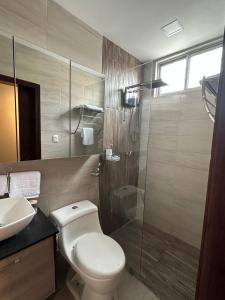 La salle de bains est pourvue de toilettes, d'une douche et d'un lavabo. dans l'établissement Kiran Lodging Guayaquil, à Guayaquil