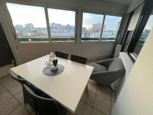 a white table and chairs in a room with windows at Appartement 3 Chambres Evry plein Centre ville in Évry-les-Châteaux