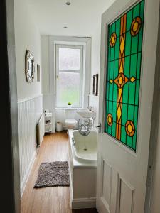 a bathroom with a stained glass window on the door at THE LAZY LION - Spacious 2 Bedroom - Town Centre Holiday Home Apartment in Port Glasgow