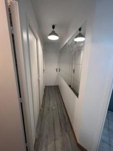 a hallway with white walls and wooden floors and two lights at Appartement 3 Chambres Evry plein Centre ville in Évry-les-Châteaux +20 photos