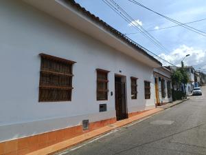 un edificio blanco con ventanas en el lateral de una calle en Casa Carambolo en Cali