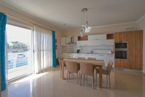 a kitchen with a table and chairs and a large window at Riviera Holiday Apartments - Seafront - Wifi in Marsaskala
