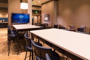 a restaurant with tables and chairs and a flat screen tv at Fairfield Inn & Suites by Marriott New Orleans Downtown/French Quarter Area in New Orleans