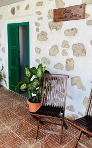 a porch with two chairs and a wall with a green door at Casa Abuela Inés in Puerto del Rosario