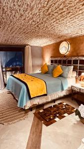 um quarto com uma cama e um relógio na parede em Villa Lulu Geribá em Búzios