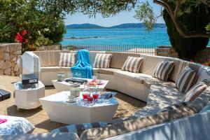 eine Terrasse mit Sofas und Blick auf das Wasser in der Unterkunft Luxury Villa Bella Vista with Swimming Pool in Betina