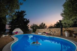einen Pool in einem Garten mit Sonnenuntergang im Hintergrund in der Unterkunft Luxury Villa Bella Vista with Swimming Pool in Betina