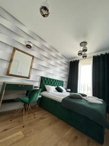 a bedroom with a bed and a mirror and a chair at Brand New !!! Baltic Marina Residence Sauna & Fitness Apartments- Royal Green Apartments, Ferienwohnung polnische Ostsee in Kołobrzeg