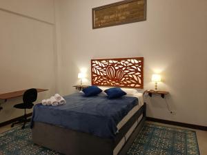 Schlafzimmer mit einem Bett mit blauer Bettwäsche und blauen Kissen in der Unterkunft Casa Carambolo in Cali