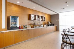 uma cozinha com armários de madeira e um frigorífico em SpringHill Suites by Marriott San Angelo em San Angelo