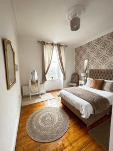 1 dormitorio con cama y alfombra en el suelo en THE LAZY LION - Spacious 2 Bedroom - Town Centre Holiday Home Apartment, en Port Glasgow