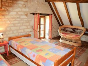 ein Schlafzimmer mit einem Bett und einem Stuhl in der Unterkunft Gîte Paulmy, 4 pièces, 7 personnes - FR-1-381-321 in Paulmy