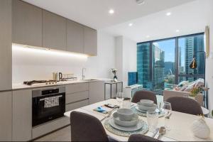 uma cozinha e sala de jantar com mesa e cadeiras em Modern 1 BR Apt on Southbank #Australia108#AU2117 em Melbourne