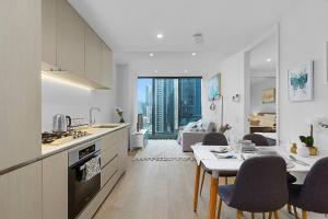 uma cozinha e sala de estar com mesa e cadeiras em Modern 1 BR Apt on Southbank #Australia108#AU2117 em Melbourne